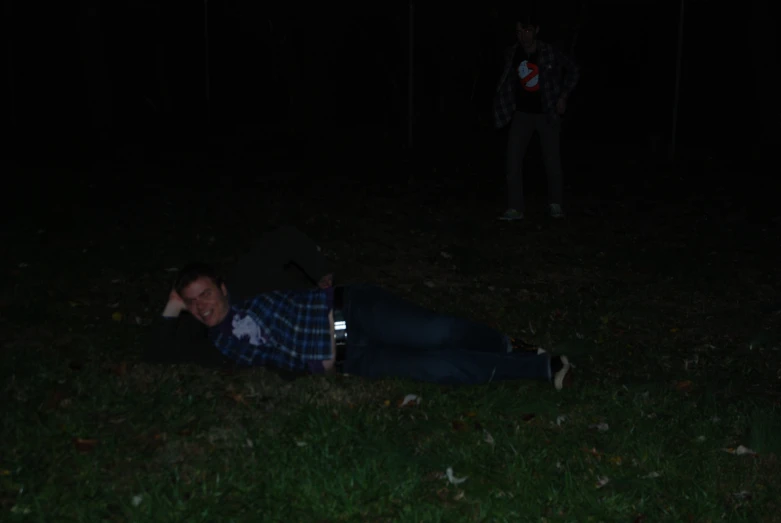 a man is laying in the grass with his cellphone