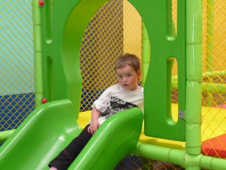 the child is on a play mat at the park