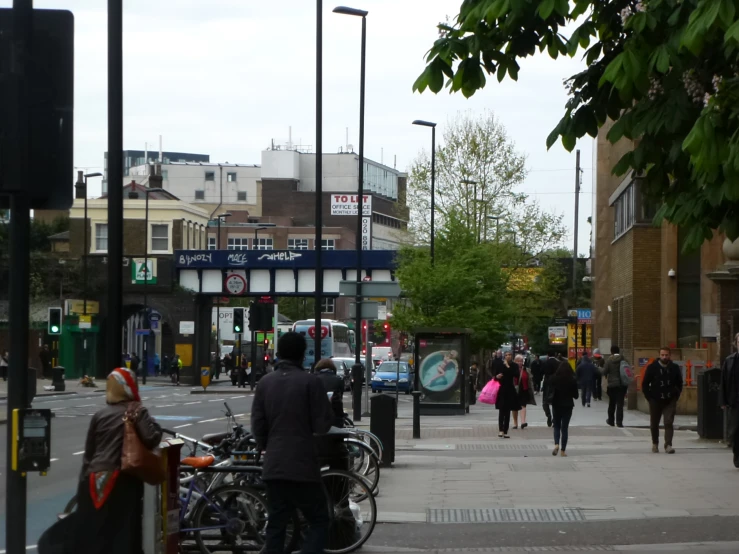 people are walking down the street near some shops