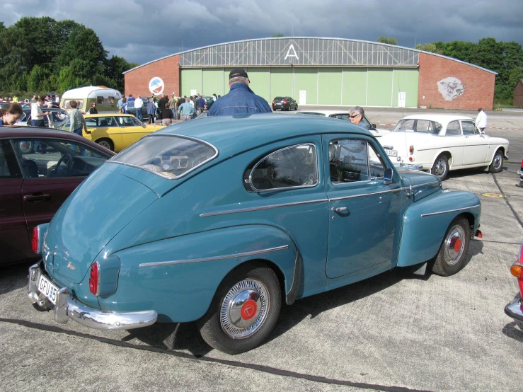 a blue and red car parked near other cars