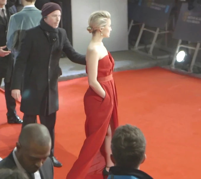 woman in red dress walking down the red carpet