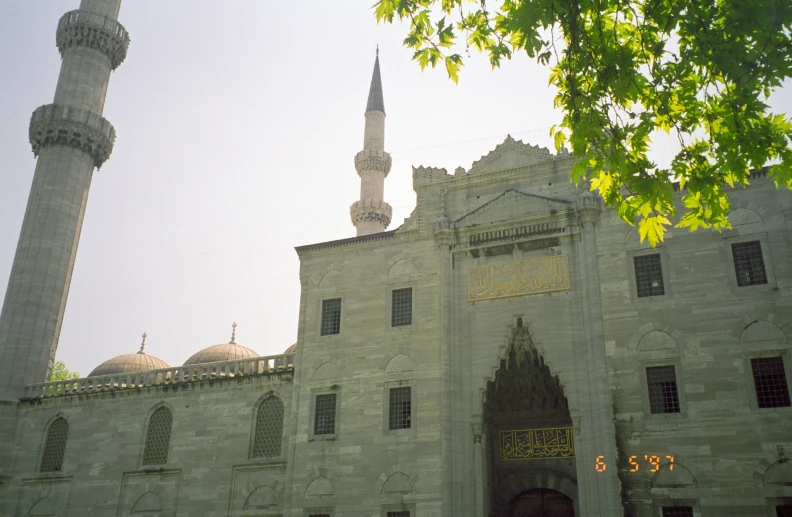 an old building that is under a tree with a tall roof