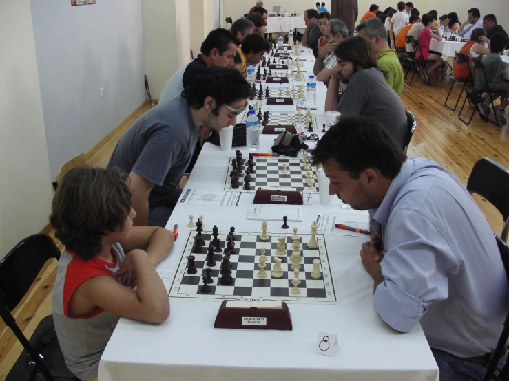 a man is playing chess on the long table