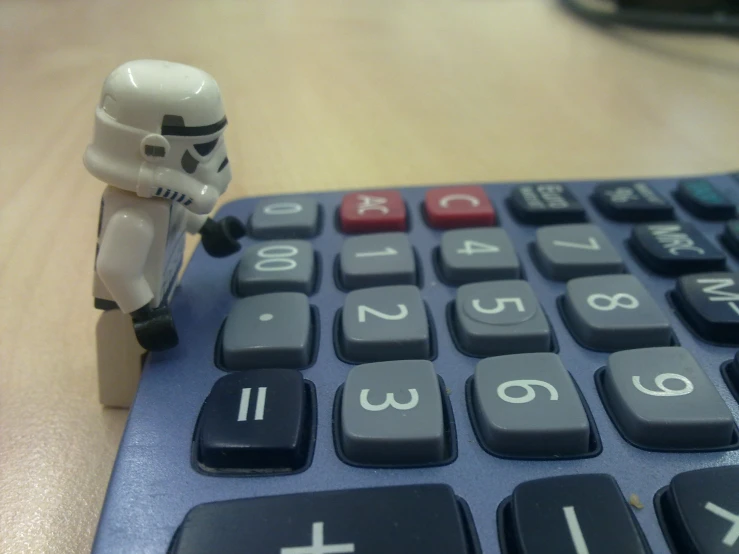 small figure with calculator sitting on top of it