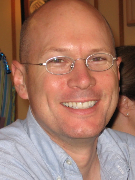 a man is wearing glasses and smiling