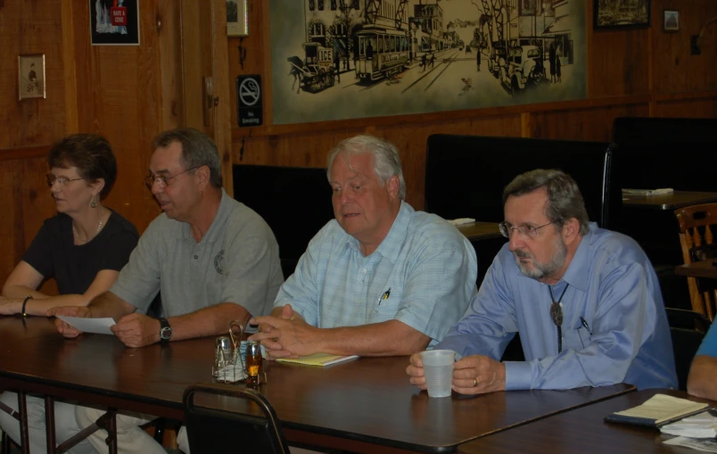 five people at table sitting in a boardroom