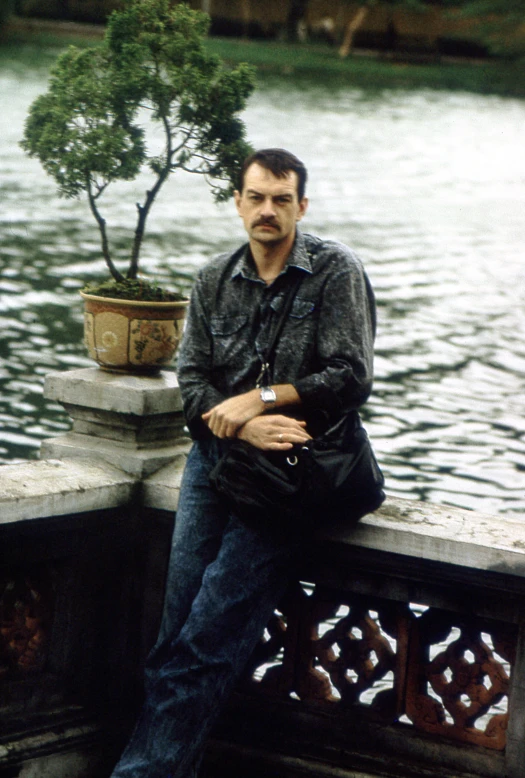 a man sitting down with a tree on the edge of his head