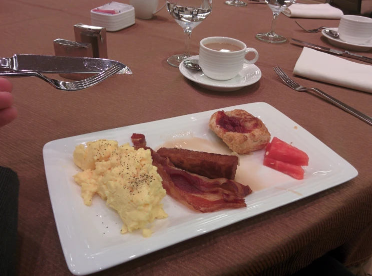 a square plate of bacon, eggs and coffee