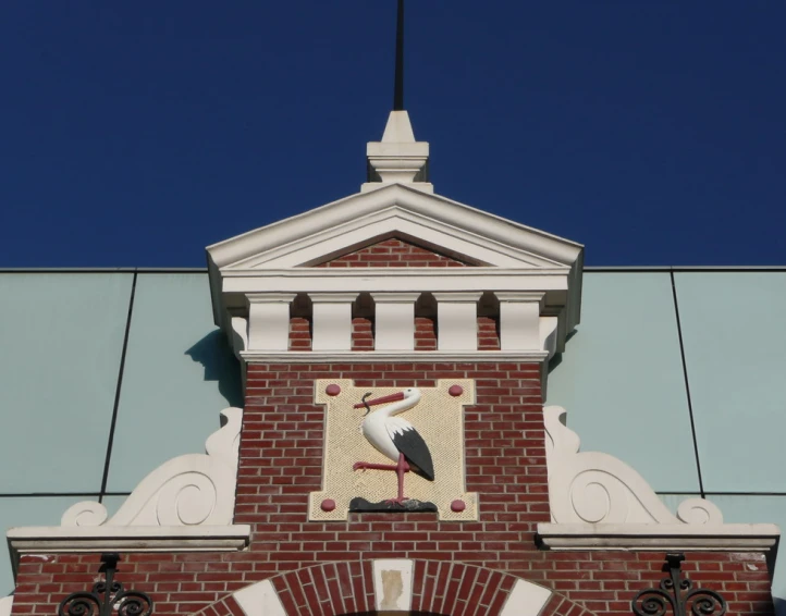 the bird is perched on the building and the sign is clearly visible