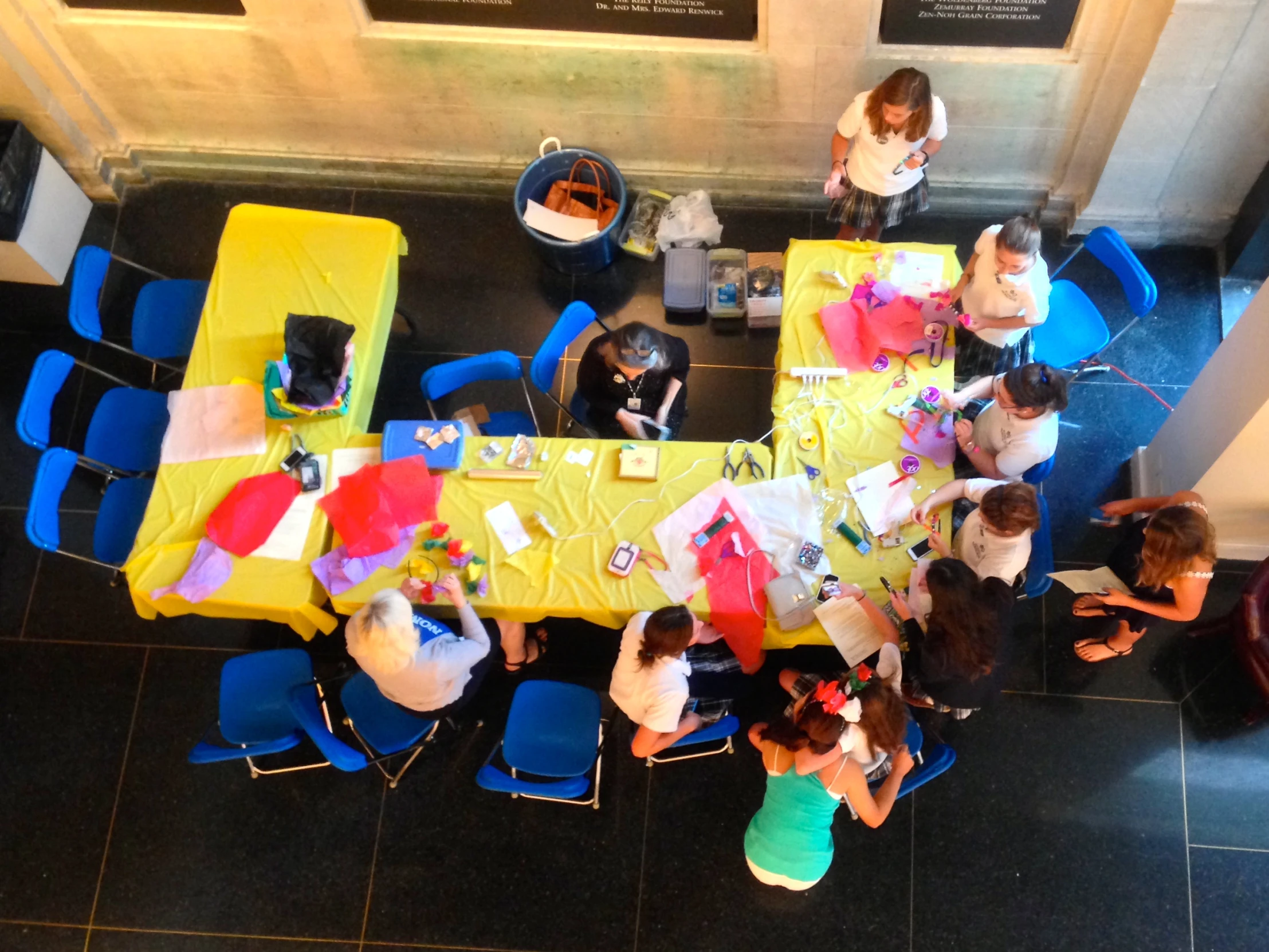 several s are eating at a long table with yellow clothed tables