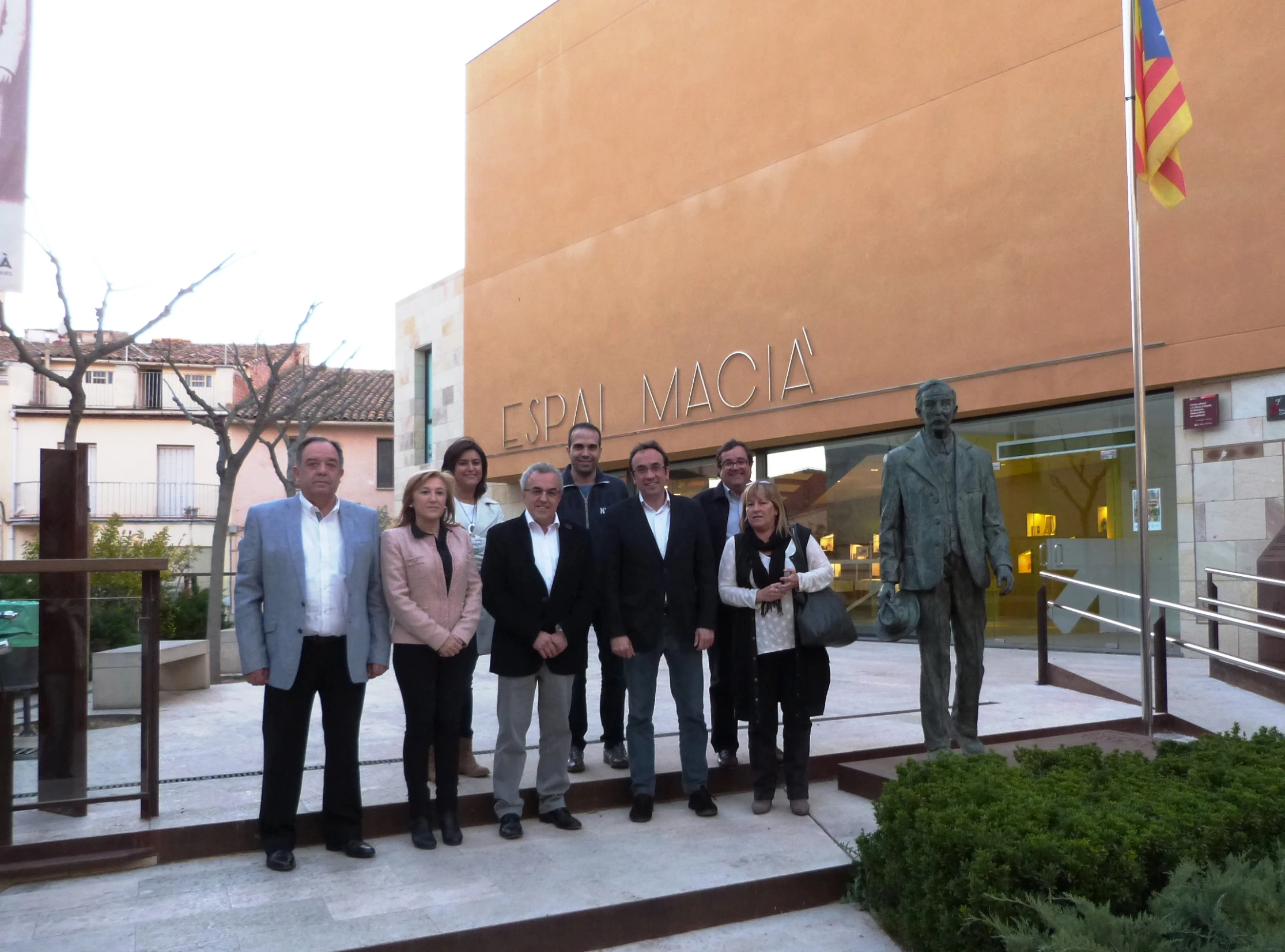 several people stand in front of the front entrance of a museum