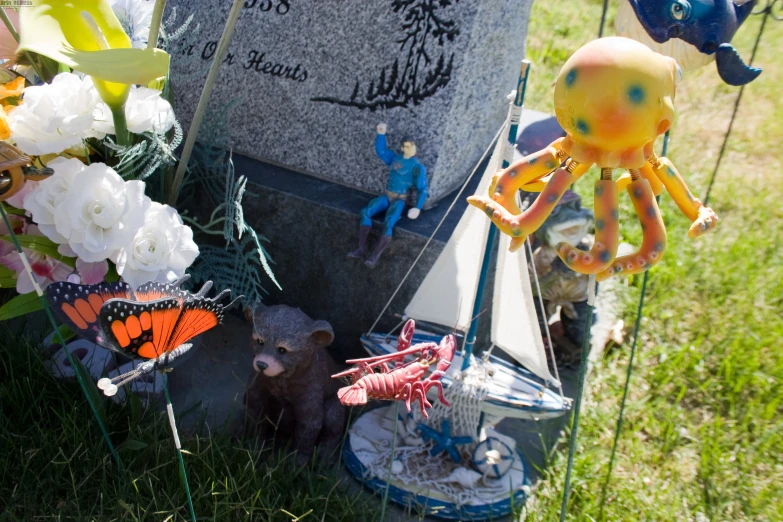 a gravestone with small animal figurines placed next to it