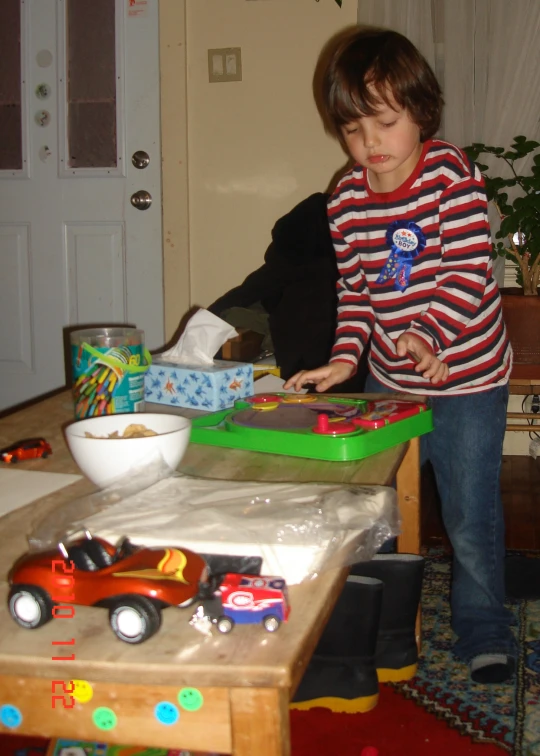 a little girl playing with toy vehicles on the table