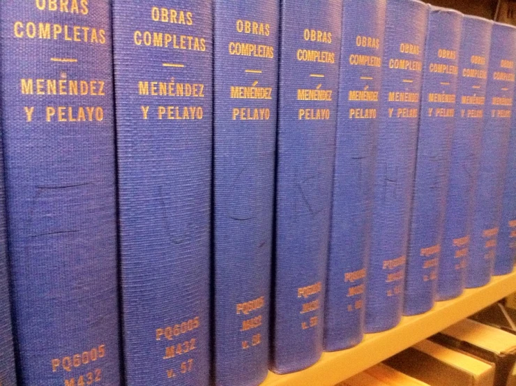 a row of blue book on a white shelf
