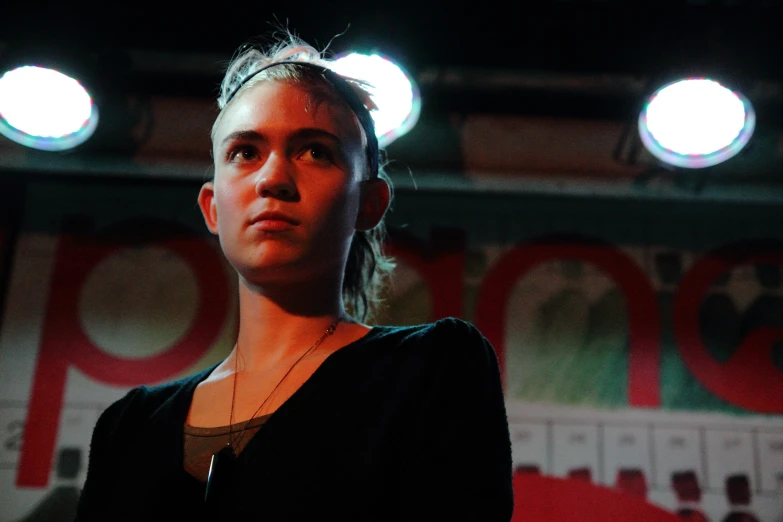 the woman in a black shirt is standing in front of some lights