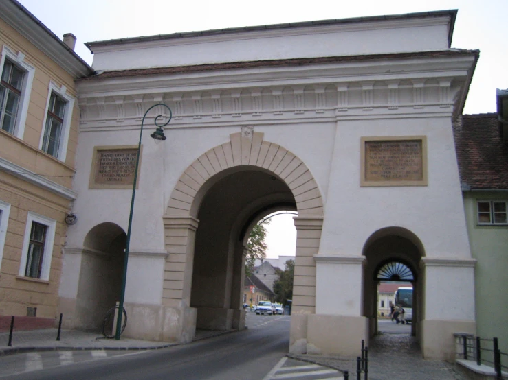 an archway near a street with houses on both sides