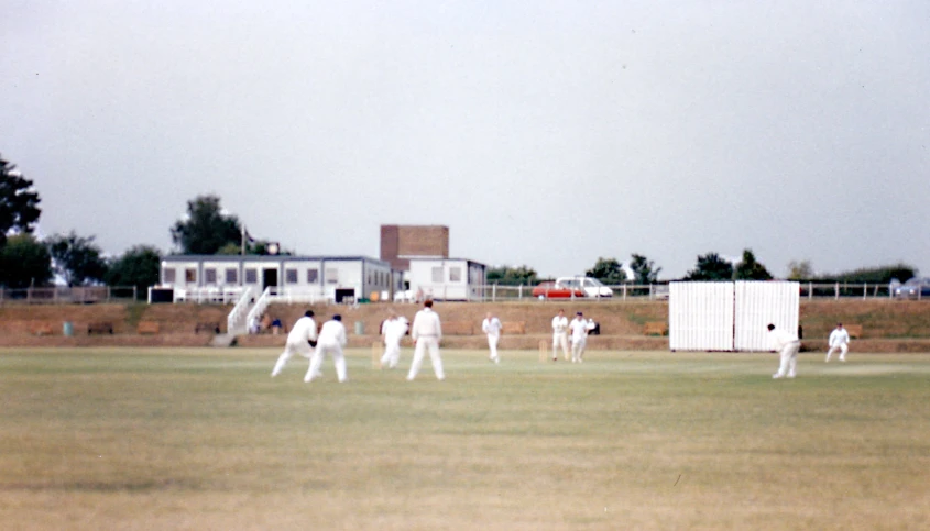 a group of men playing a game of cricket on a field