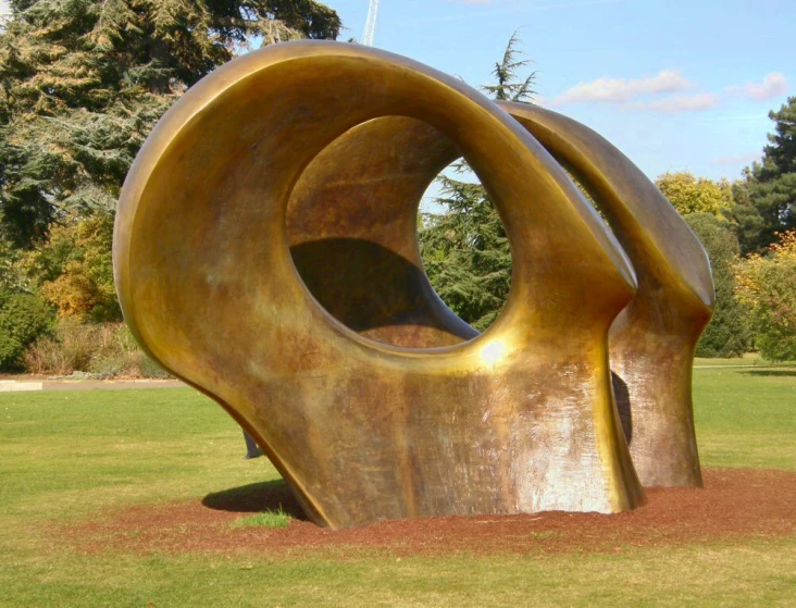 a big metal statue with a tree in the back