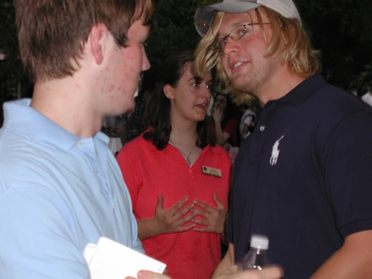 several people standing and talking at an outdoor event