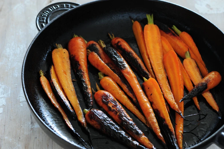 an iron set filled with carrots that have been fried