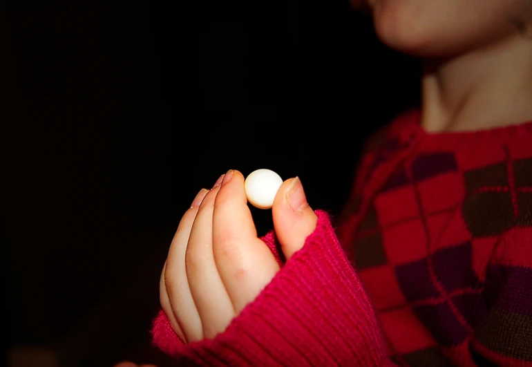 a person wearing a red sweater holding a white ball