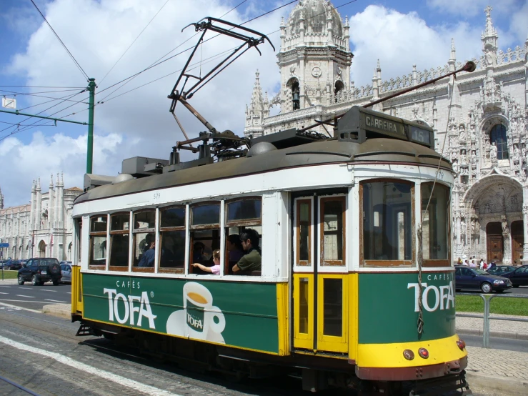 the trolley in front of a large building that says  on the side