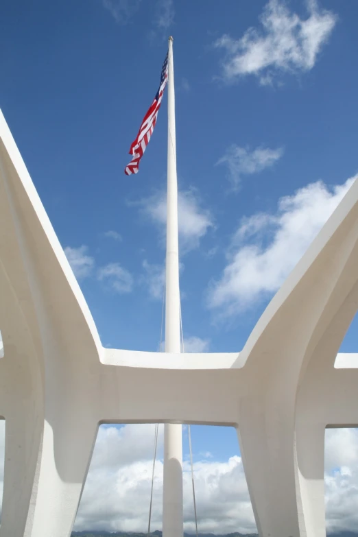 an american flag is flying in the distance under a tall monument