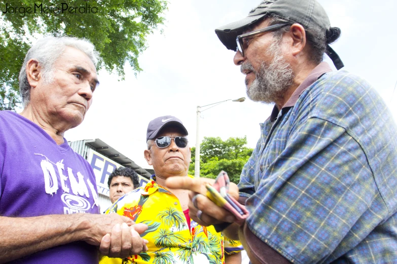 a man handing another man soing with his hand