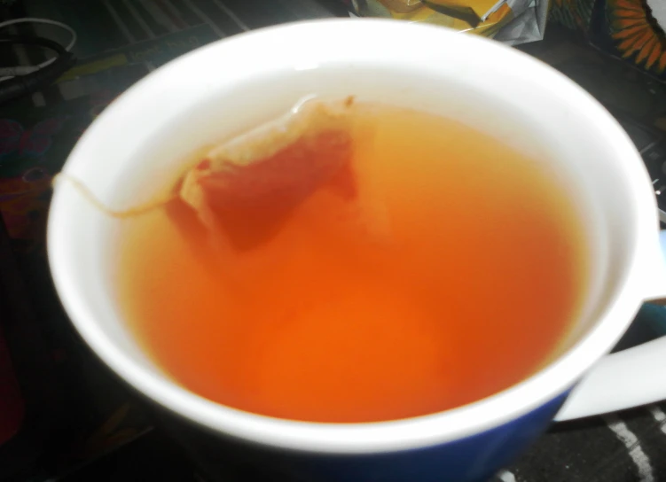 a cup filled with liquid next to a cup of tea