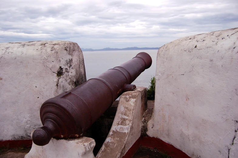 a cannon leaning against some old concrete