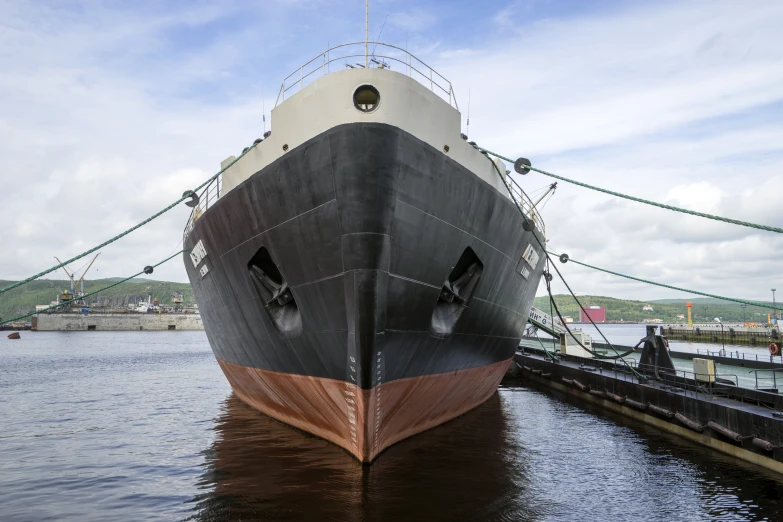 a large boat tied to a dock near the water