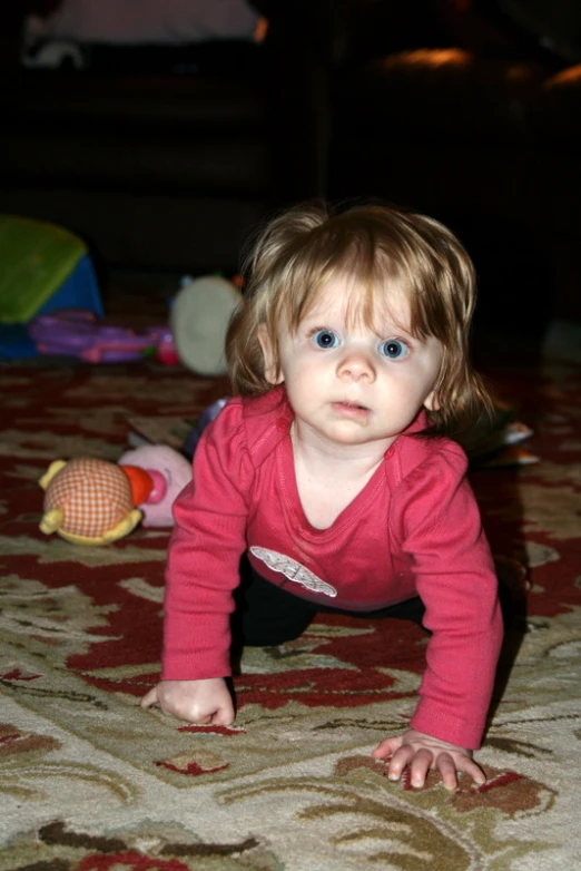 a baby crawling on its stomach while looking at soing