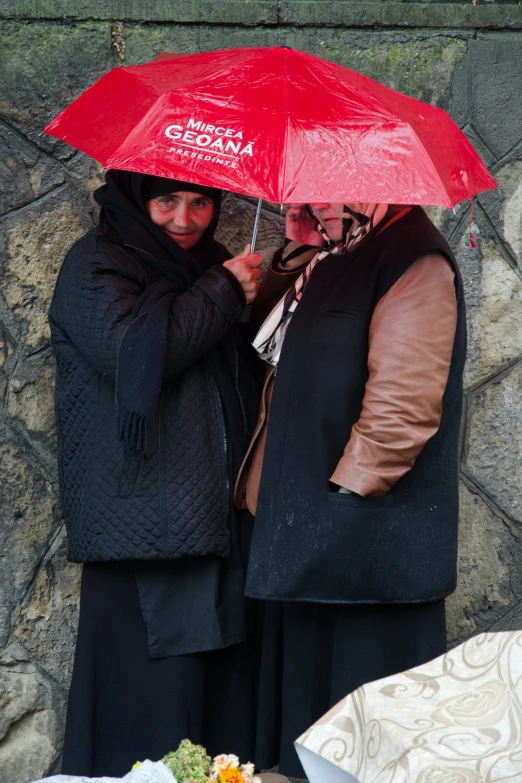 two people in a courtyard holding umbrellas in the rain