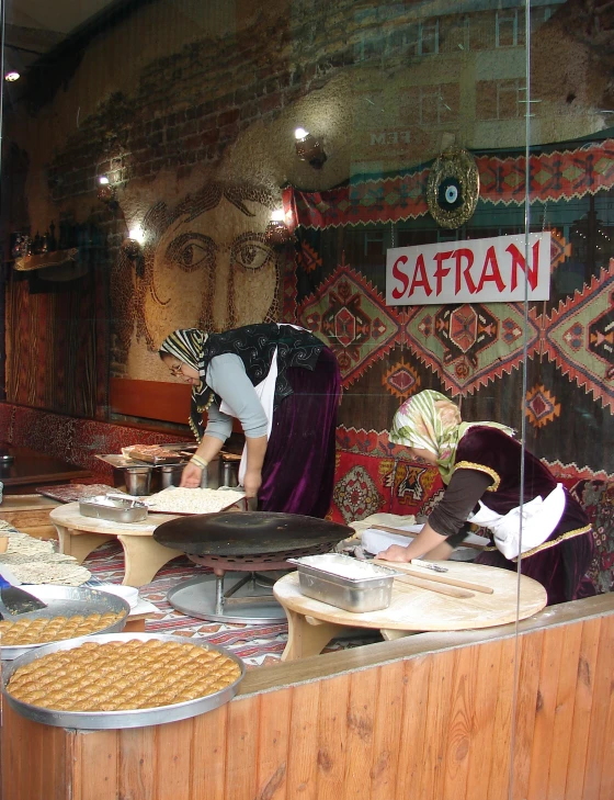 women are preparing plates on the table at a bakery