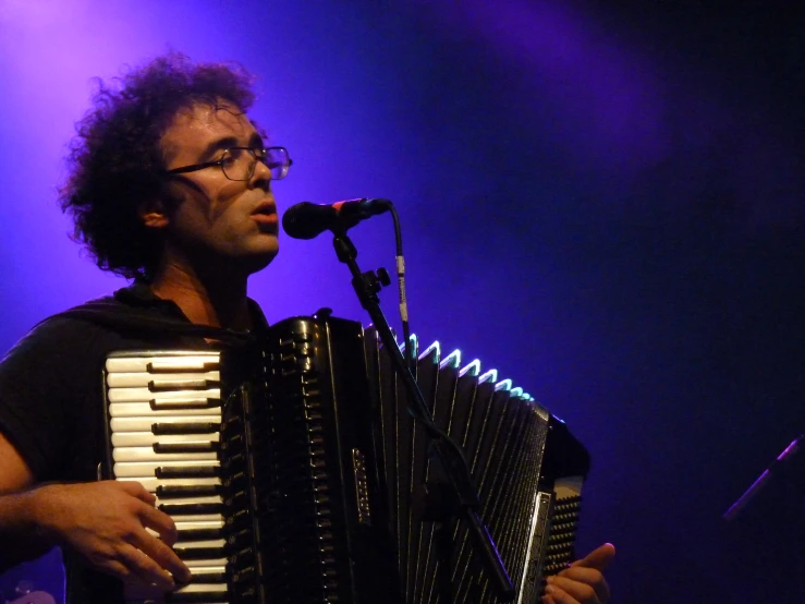 an african musician plays an accordion in front of the audience