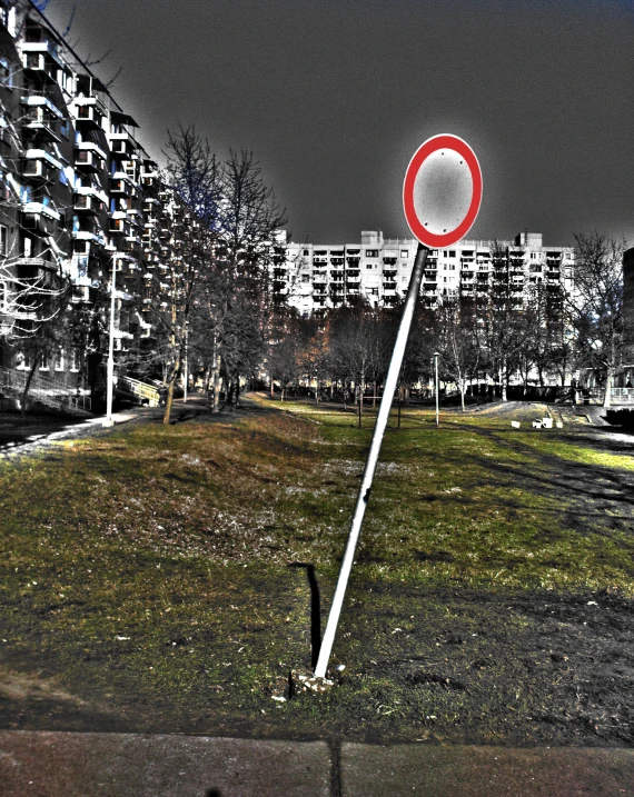 a sign in the grass near a row of buildings