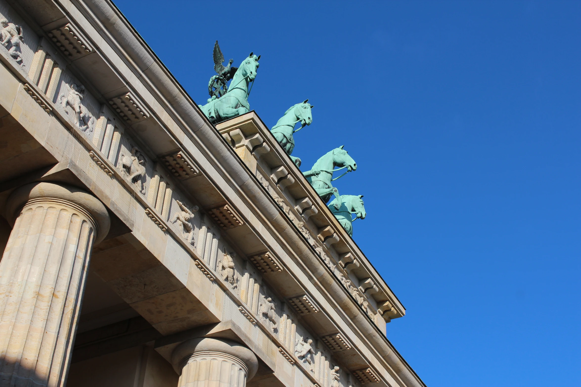 the top of some statues that are on a building