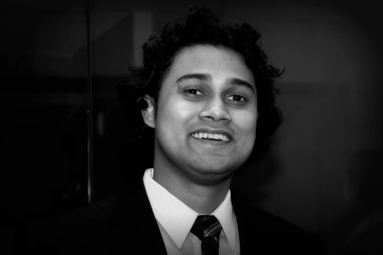 a man in a suit standing next to a mirror