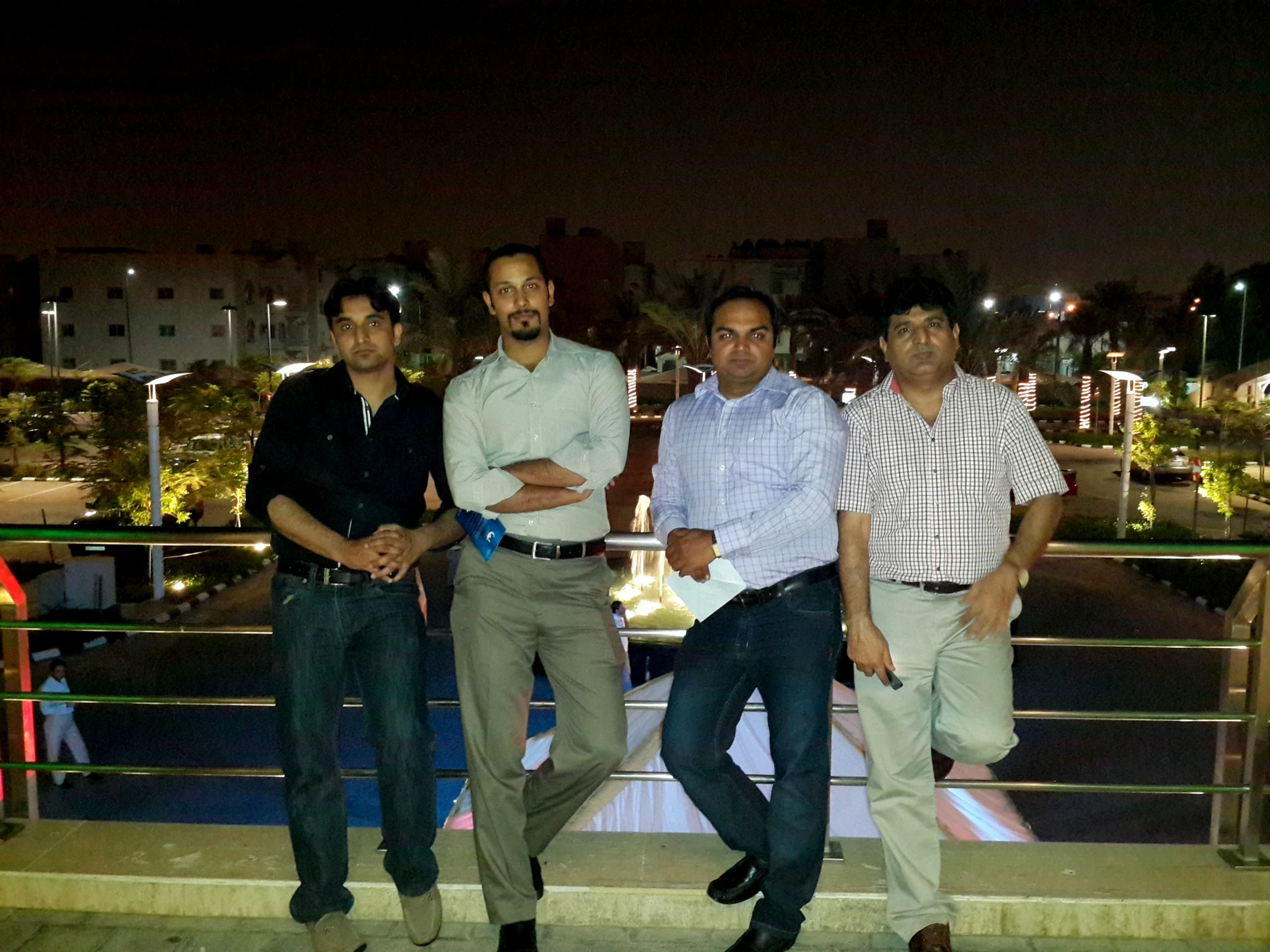 four men are posing on a ramp at night