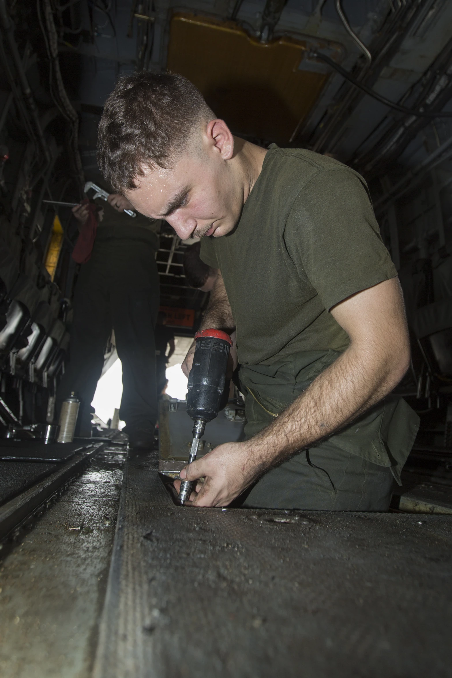 a man holding an object inside a large metal room