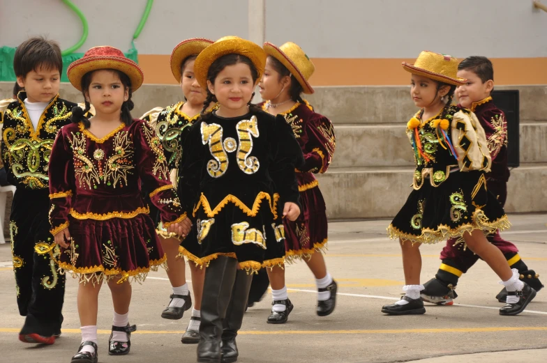 the children are dancing and dressed in mexican folk costumes