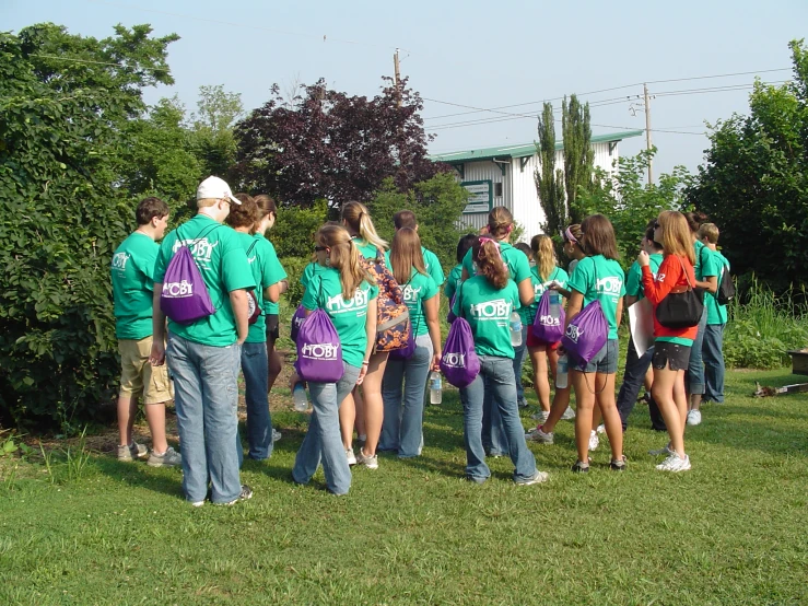 a group of girls in green shirts standing next to each other