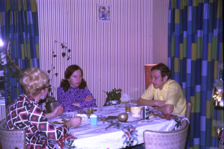 a man and woman sitting at a table with two men sitting by the table