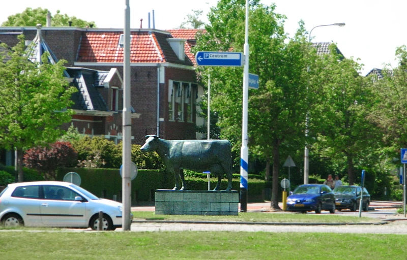 an image of a cow statue near a park