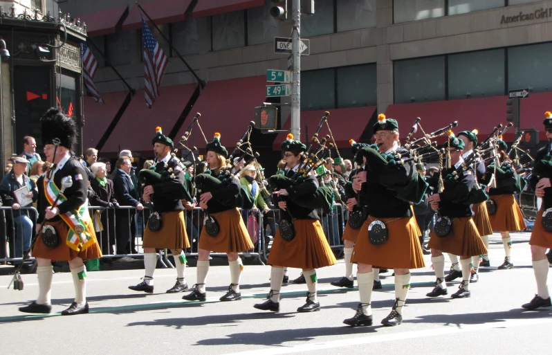 many pipers and musicians are marching down the street