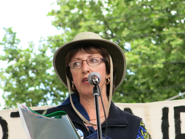 a person in a hat standing at a microphone