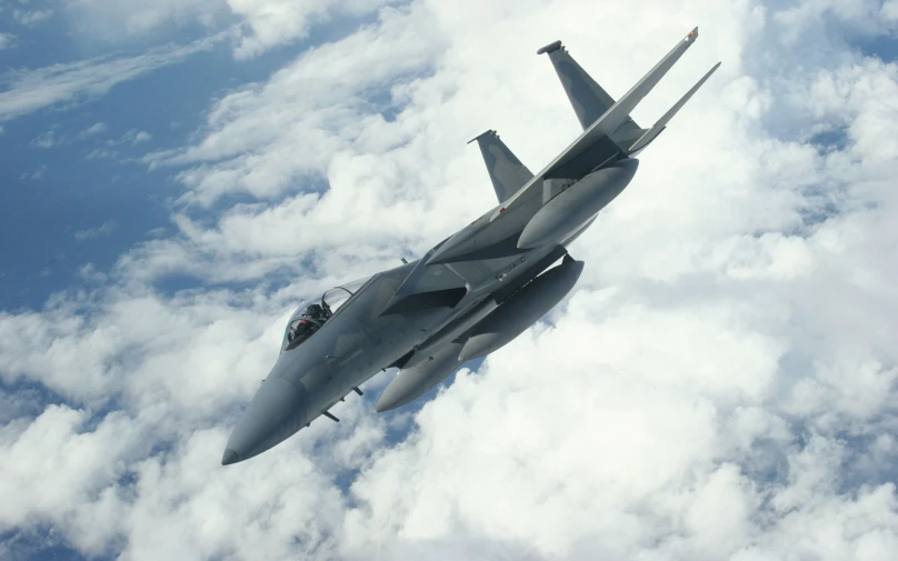 a jet flies above the clouds as it heads toward land