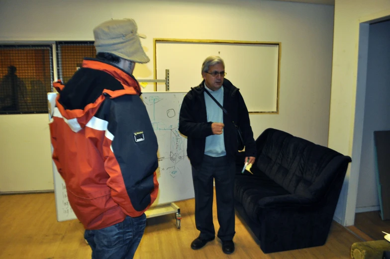 two people talking in an open room with a couch