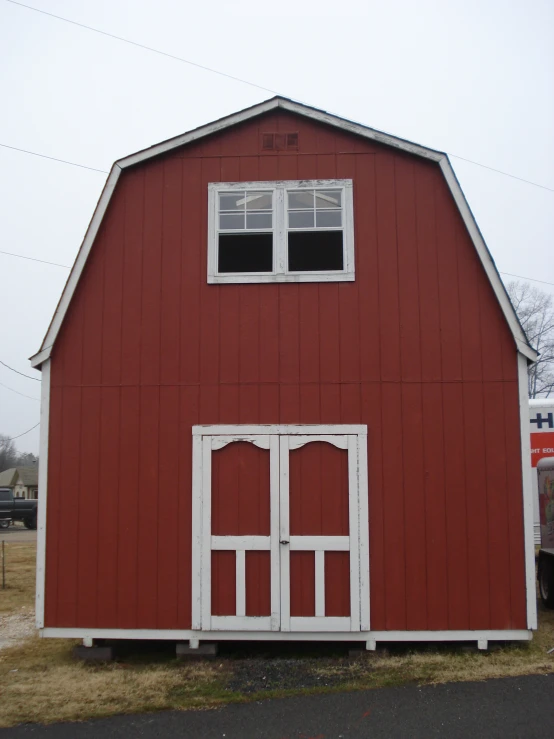 an old red barn sits in a country setting