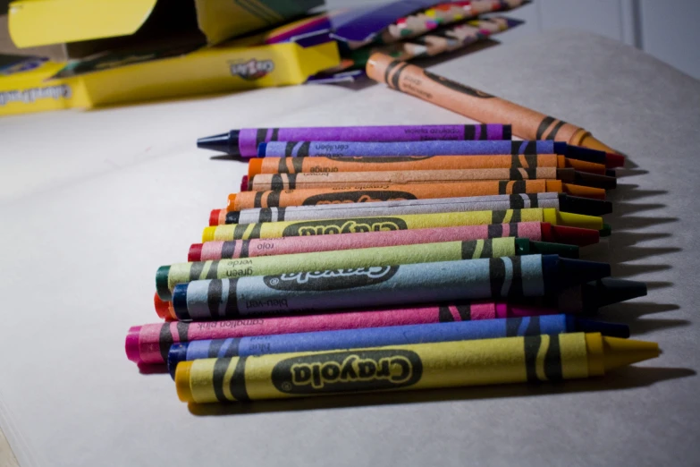 several crayons are lined up in bright, colorful papers